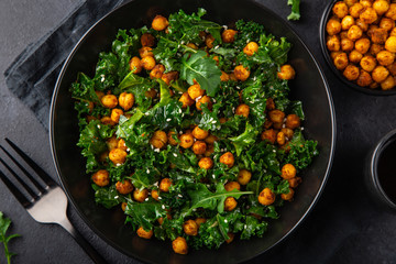 vegan healthy kale and roasted chickpeas salad in black bowl