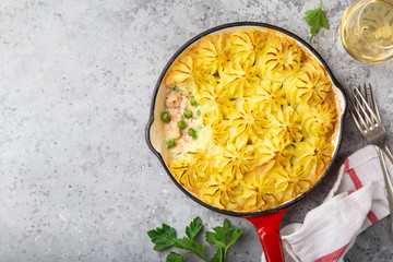 salmon  shepherd's pie. Fish in creamy sauce , mashed potatoes and vegetables casserole in enamel cast iron pan
