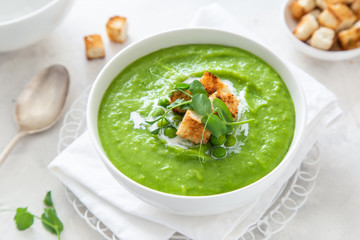 green peas cream soup in white bowl