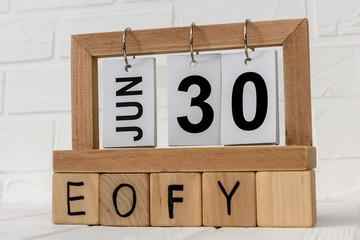 Wooden calendar with cubes and text 'EOFY' on it