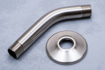 Brushed Nickel Metal Shower Arm and Flange isolated on gray background.