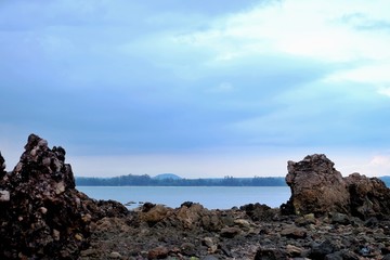 Fototapeta na wymiar Silhouette seascape with sea stones shadow and blue sky background 