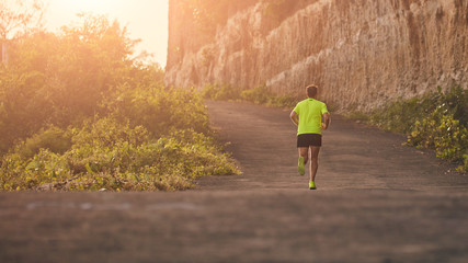 Man jogging on a downhill / uphill in suburb mountain road.