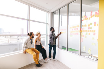 young business team doing brainstorming with sticker notes in office