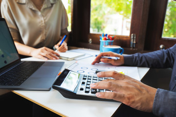 Businessman hands, he is pressing the calculator to calculate the amount