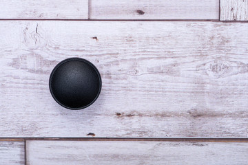 Classic Black Round Cabinet Knob isolated on wooden background.