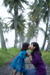 Naklejka premium mom and kid in beautiful coconut country road in the morning
