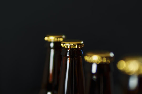 Group of glass beer bottles on dark background with copyspace
