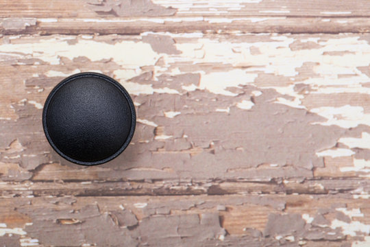 Classic Black Round Cabinet Knob isolated on wooden background. © bjphotographs