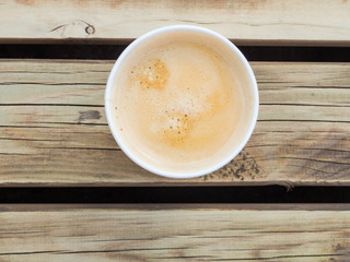 Cup of coffee to go on the wooden table. Street coffee, top view.