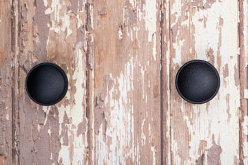 Classic Black Round Cabinet Knob isolated on wooden background.