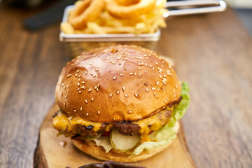 Cheeseburger with french fries on the wooden table