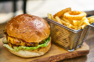 Cheeseburger with french fries on the wooden table