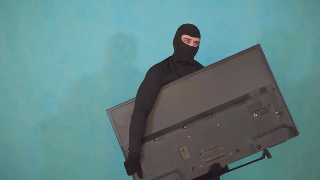 masked thief Balaclava who stole the TV and looks tired