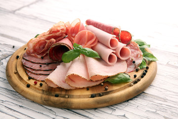 Food tray with delicious salami, pieces of sliced ham, sausages,salad and vegetable. Meat platter...