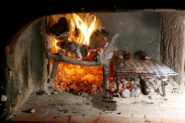 Barbeque oven with grill. Bright flames, wood, embers and ashes.