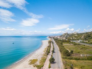 Vista aerea della città di Roccella Ionica o Jonica in Calabria, con il porto delle Grazie, il castello Carafa e la bellissima spiaggia sabbiosa con il mare Mediterraneo blu. 