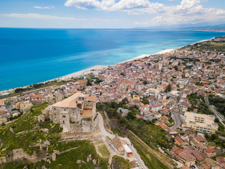 Fototapeta na wymiar Castello Carafa di Roccella Ionica in Calabria che si affaccia sul mare Mediterraneo. Vista Aerea. Paese con Bandiera Blu.