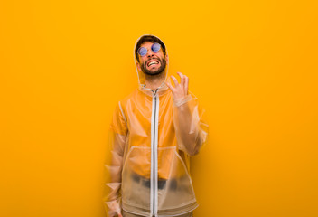 Young man wearing a rain coat very scared and afraid