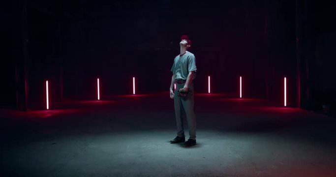 FIXED WIDE Caucasian professional baseball player pitcher posing against dark background. 4K UHD 60 FPS SLOW MOTION