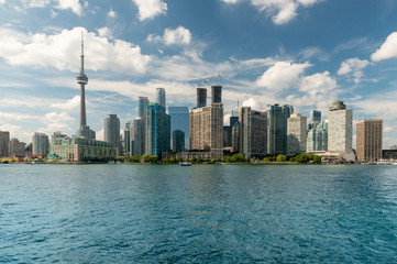 Lake Ontario view, City of Toronto skyline with tower and quays with trees.