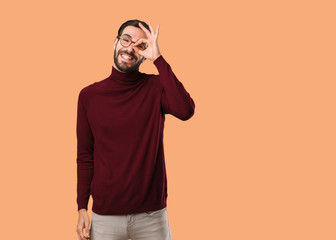 Young natural man confident doing ok gesture on eye