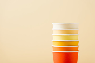 bright colorful disposable cups isolated on beige background