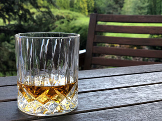 A glass of whiskey on table at garden