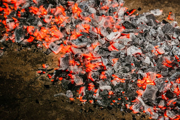 a pile of glowing coals diagonal at night