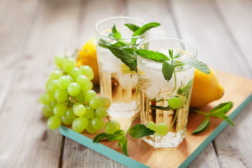 Glass of grape juice with ice on wooden table