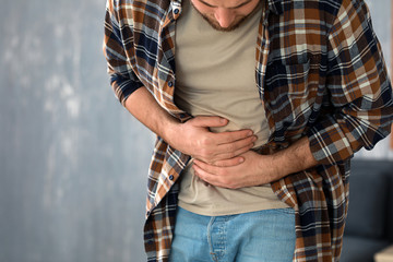 Young man suffering from stomachache at home