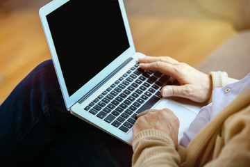 Fototapeta premium Handsome mature man using laptop at home, closeup