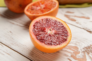 Half of fresh blood orange on white table