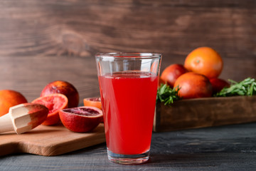 Glass of fresh blood orange juice on wooden table