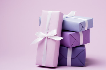 colorful gift boxes with white ribbons on purple surface