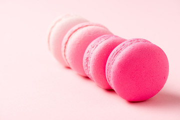 selective focus of sweet colorful macarons on pink surface