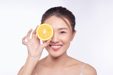 young and beautiful asian woman posing with a slice of orange on white background
