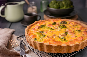 Traditional broccoli pie with salmon and cheese. Food from healthy and healthy foods. Lunch. Photo in the style of dark.