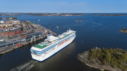 The cruise ship leaves the Helsinki port and enters the Baltic Sea through a narrow strait. Beautiful sunny spring panorama.