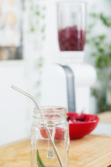 Cooking smoothies from berries. Raspberries, shaker and glass for smoothies.