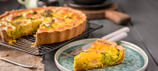 Traditional broccoli pie with salmon and cheese. Food from healthy and healthy foods. Lunch. A piece of cake in the frame on a plate. Dark photo.