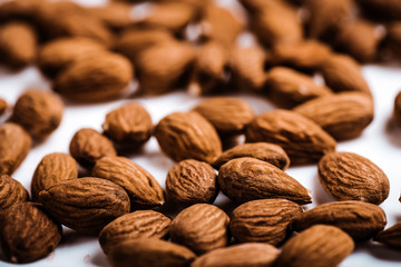 Almond on white background close up. Raw Natural Organic Almonds Nuts Scattered. Healthy Food for Life Natural Light Selective Focus