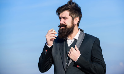 Naklejka premium I need one more cigarette. Future success. Male formal fashion. Businessman against the sky. brutal caucasian hipster with moustache. Mature hipster with beard. Bearded man smoking cigarette. smoke