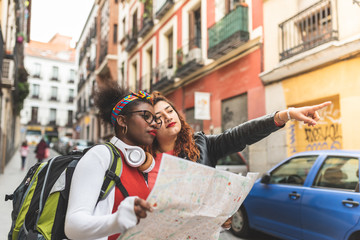 Fototapeta na wymiar Two Latin Teenage Girls Using a Map and Traveling Together.