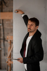 Male realtor measuring room with laser rangefinder