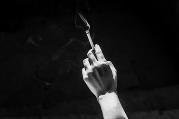 Woman smoking a cigarette. Cigarette smoke spread. Black and white photo