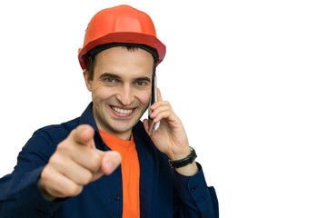 Builder with protective helmet on his head, talking on the phone,  points the finger at you, isolated, background with a copy of the space