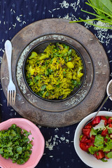 Indian basmati rice pilau (pilaf) with cilantro, spinach, spices, herbs in bowl with fried, cooked vegetables. Vegan lunch, vegetarian dinner, healthy food