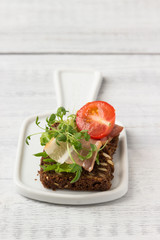 Sandwich with bacon, tomato and herbs  sprouts.