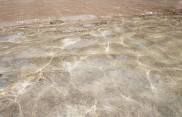 Transparent clean sunny ocean sea water waves for background and texture.